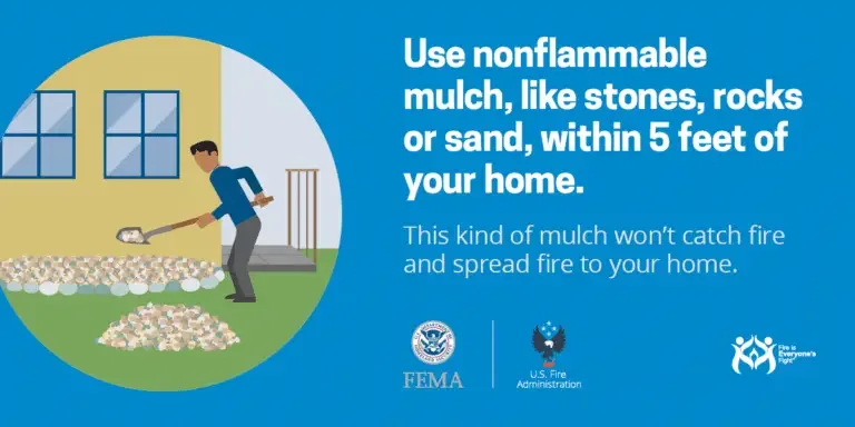 A man using a shovel to spread nonflammable mulch around his home with advice on using stone, rock, or sand mulch to prevent fires, endorsed by fema and the us fire administration.